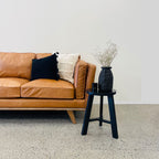 Angled styled view of the Fergus Sofa in Toffee leather, highlighting its inviting design, premium leather upholstery and solid oak legs.