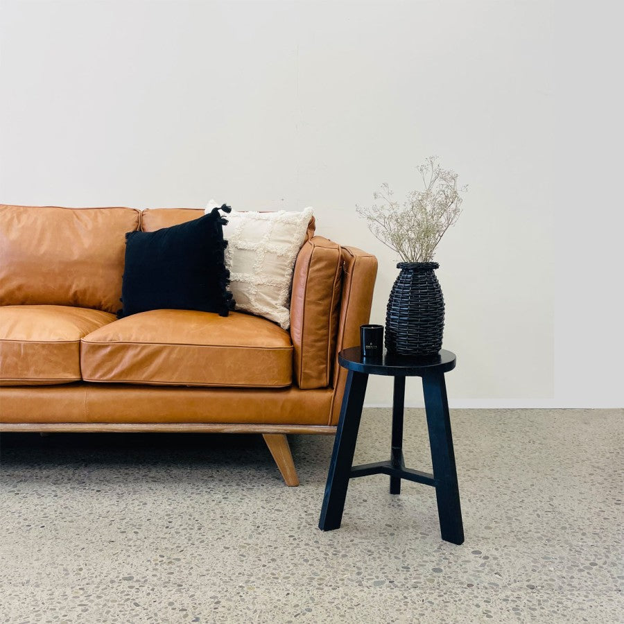 Angled styled view of the Fergus Sofa in Toffee leather, highlighting its inviting design, premium leather upholstery and solid oak legs.