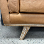 Close-up of the Fergus Sofa's solid oak leg, highlighting the natural timber grain and quality craftsmanship.
