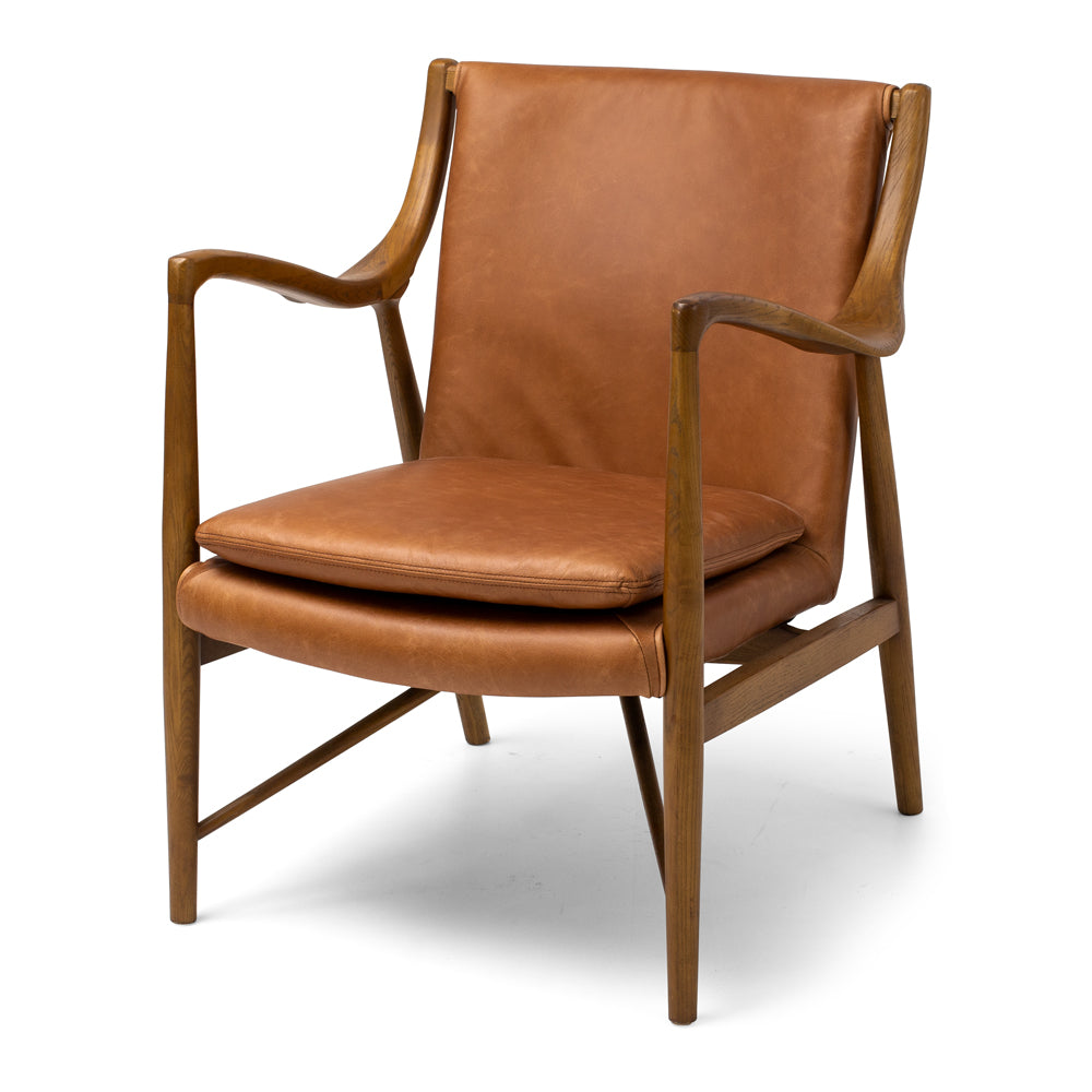 Angled view of the Finn Occasional Chair in Tan, showcasing its sculptural solid ash timber frame and premium aniline leather upholstery.