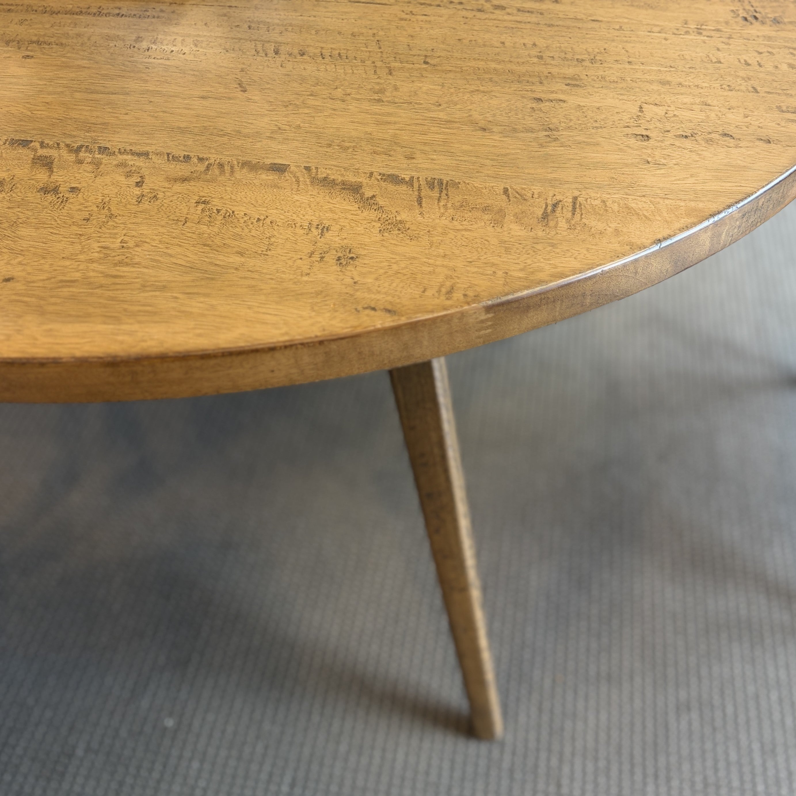 Close-up of the Florence Round Dining Table's solid mango wood tabletop, showcasing the rustic finish and natural timber grain.