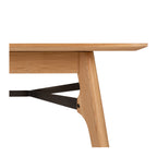 Side view of the Flow Dining Table, highlighting the slim tabletop profile, tapered oak legs and minimalist styling.