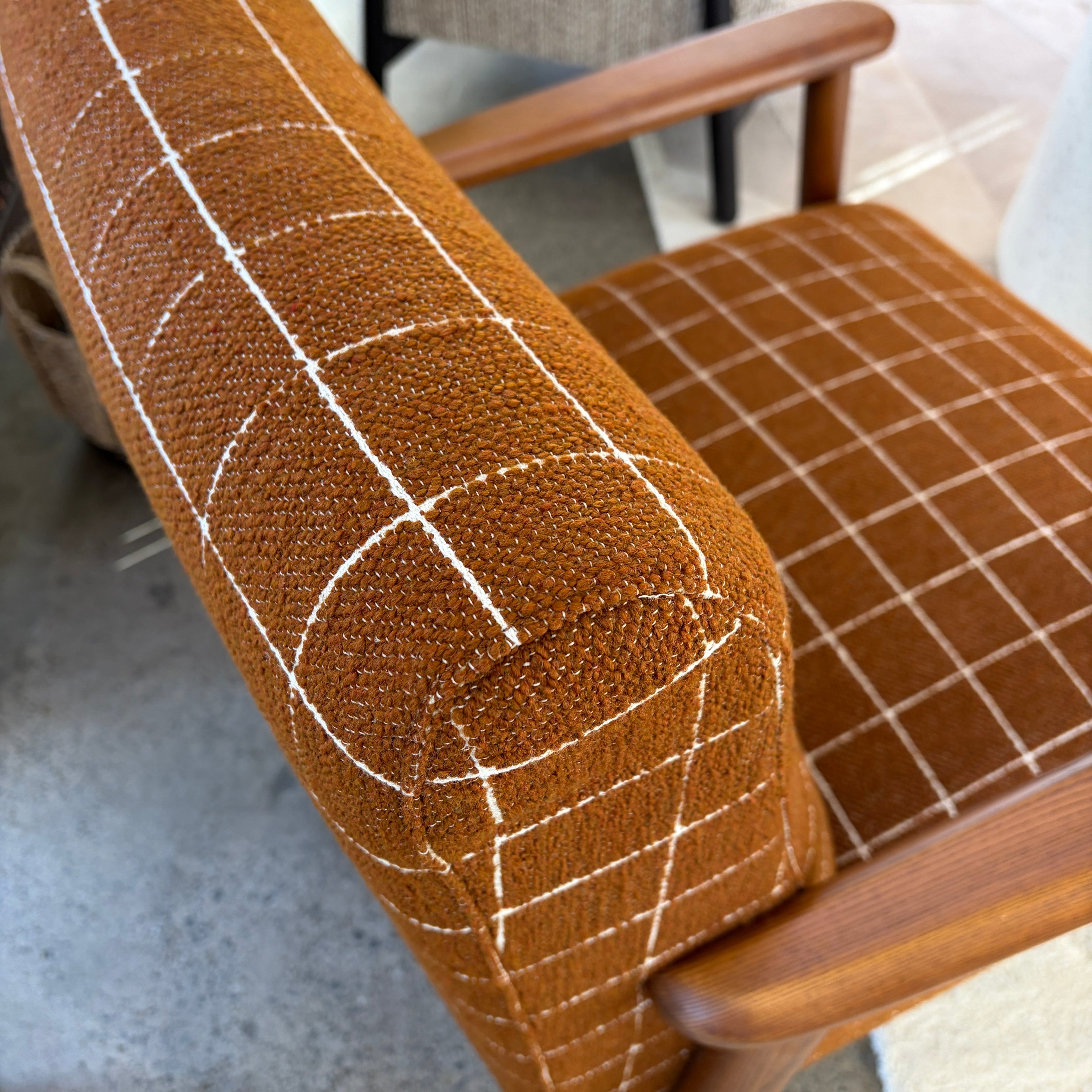 Close-up of the Frankie chair's Rust woven fabric upholstery.