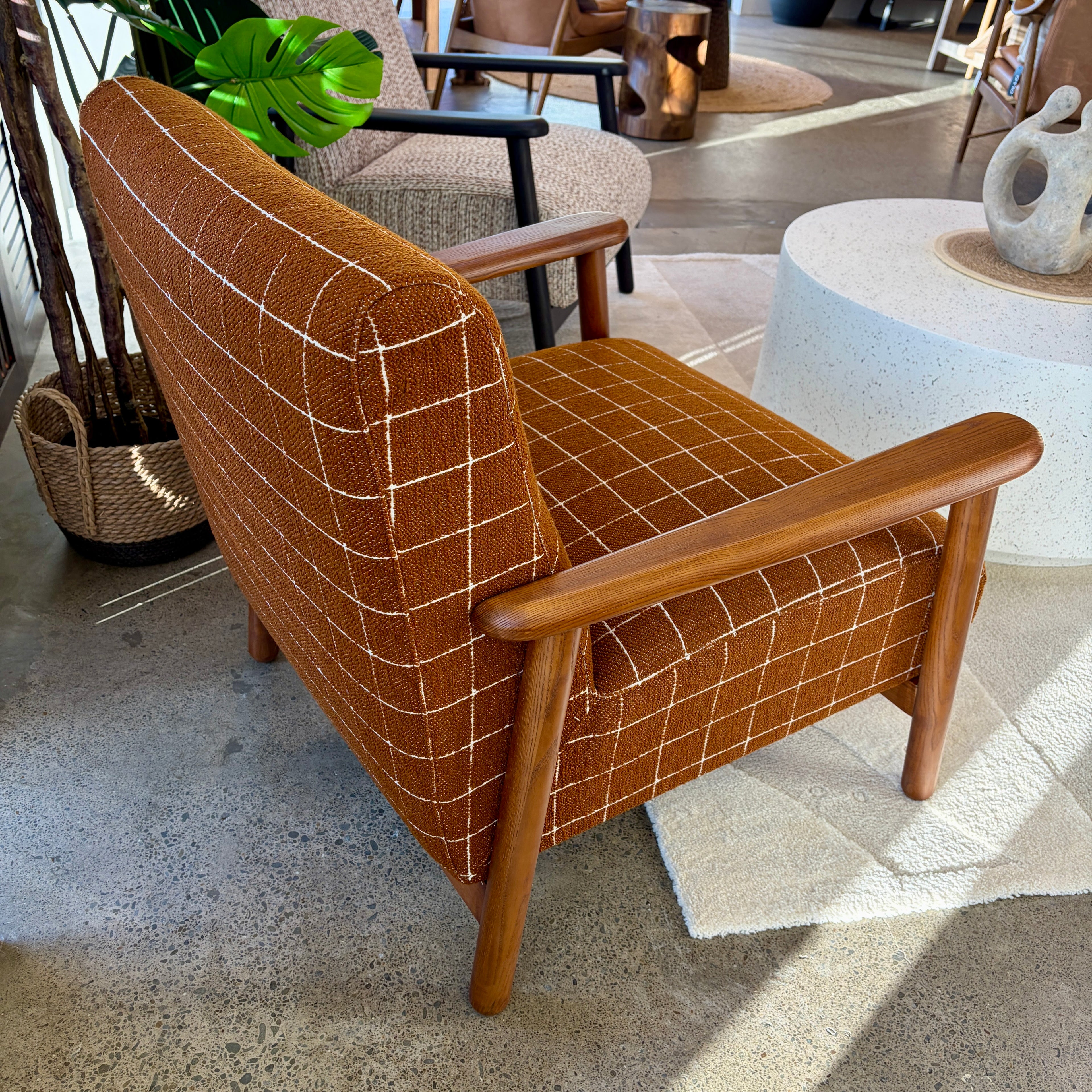 Rear view of the Frankie chair in Rust, highlighting its curved back and quality upholstery.