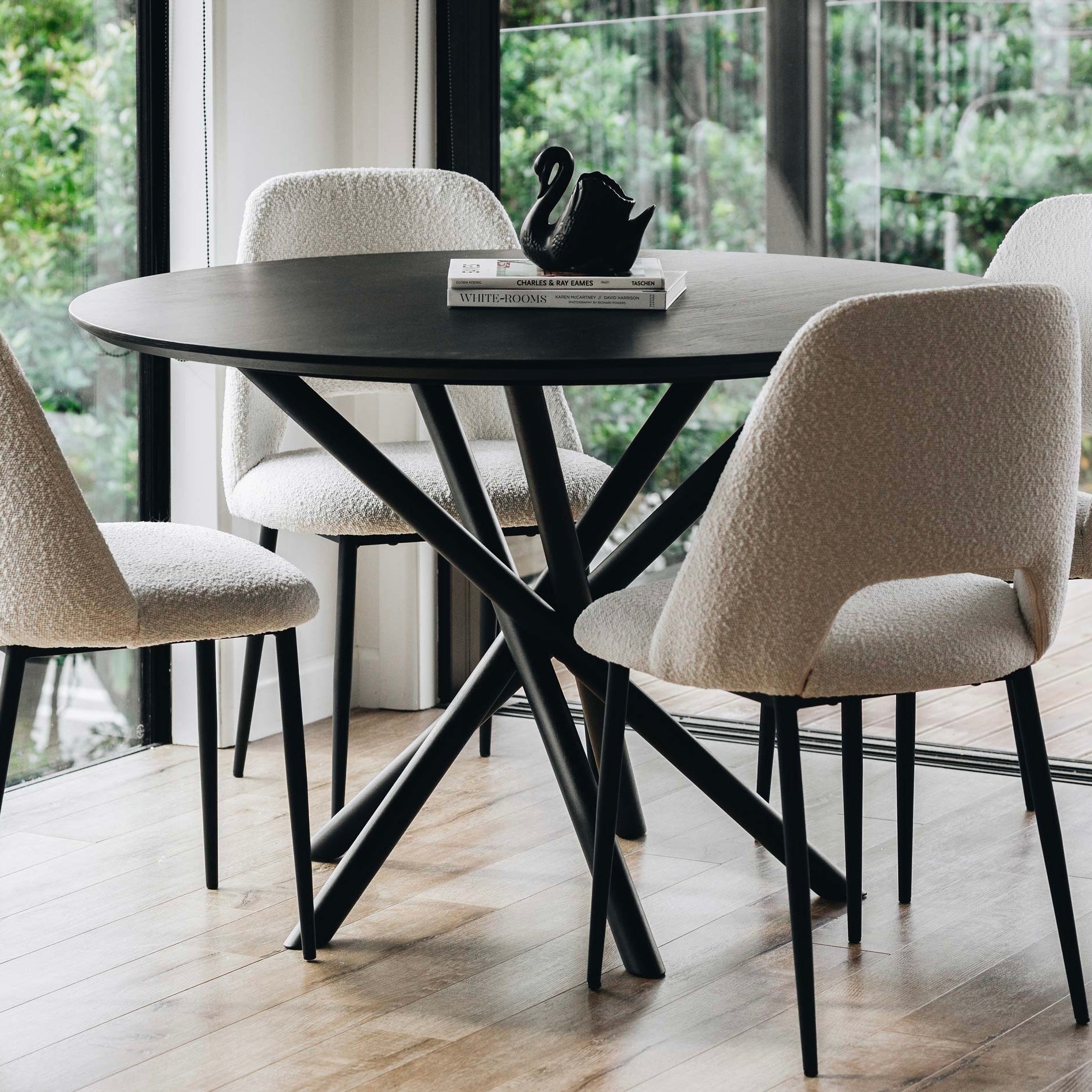 Harper round dining table in Black Oak styled in a contemporary dining room.