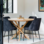 Harper round dining table with solid oak top styled in a contemporary dining room.