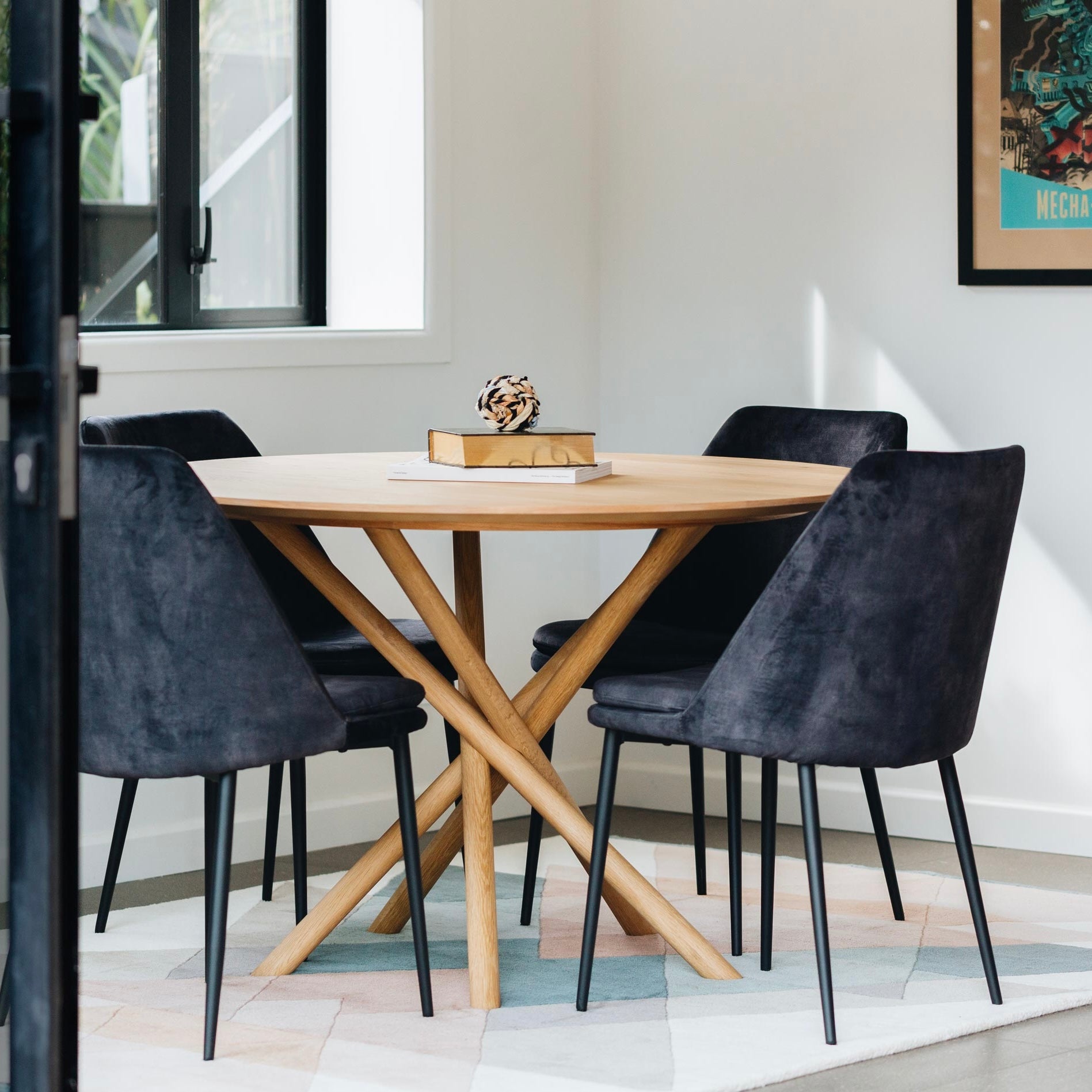 Harper round dining table with solid oak top styled in a contemporary dining room.