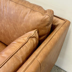 Close-up of the Hunter Leather Sofa's Caramel leather upholstery, showcasing the natural grain, stitched detailing and quality craftsmanship.