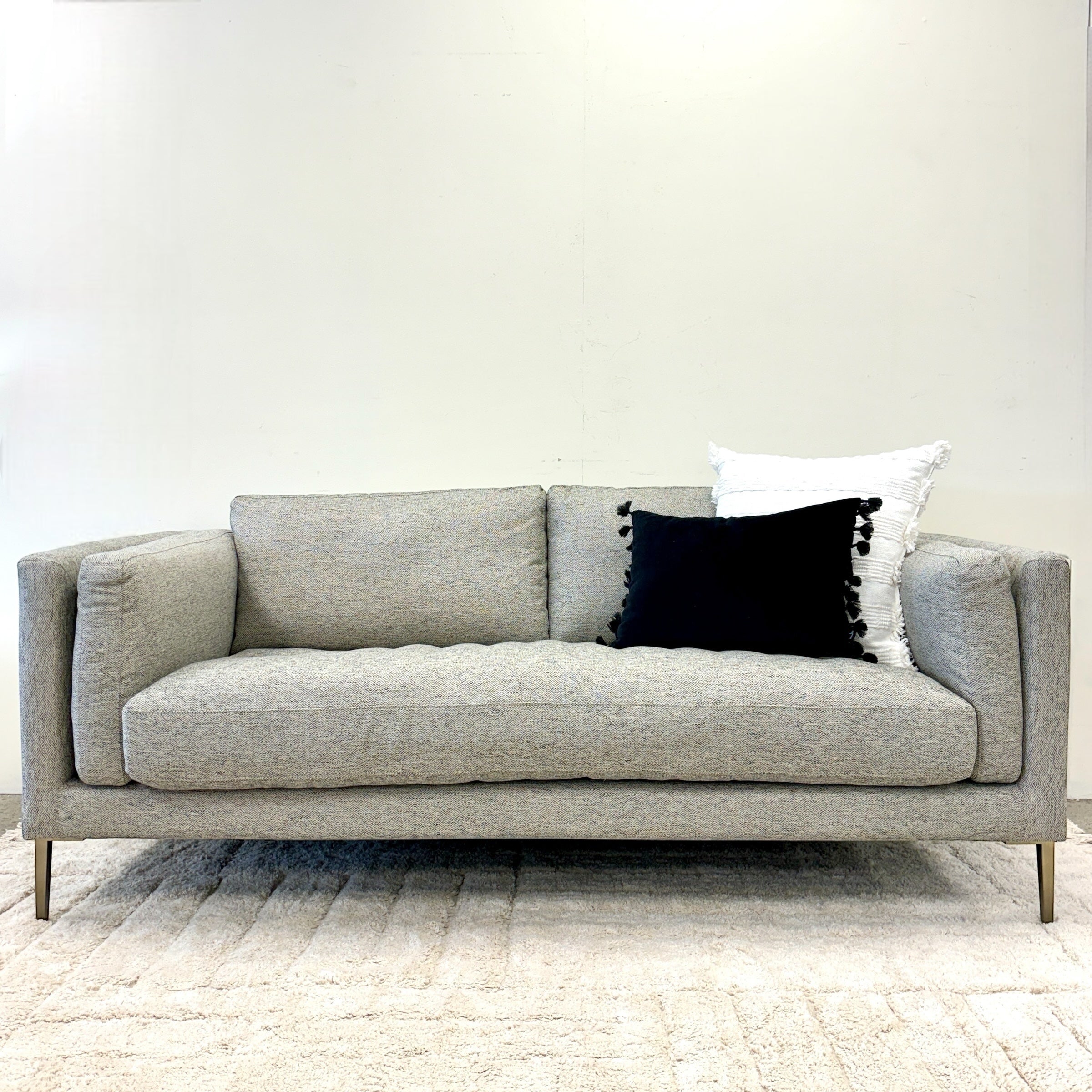 Josephine Sofa in Geo Black/White with a slim contemporary silhouette, deep seat cushions and black metal legs, styled with accessories.