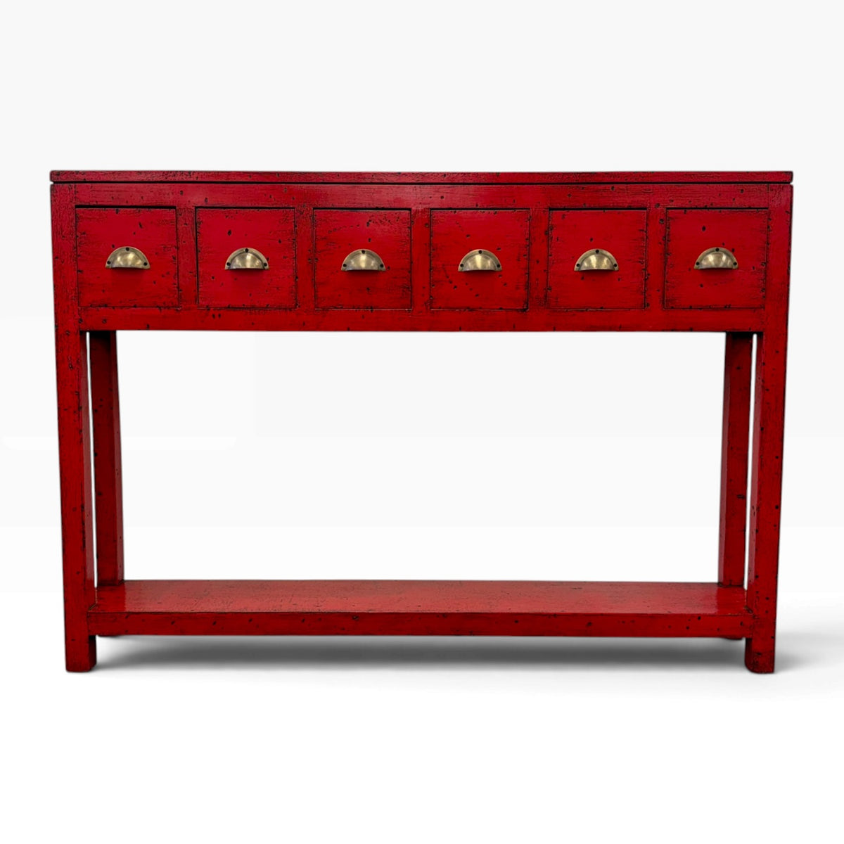 A red console table with six small drawers on the top panel, each featuring a gold-toned semicircular pull handle, and an open lower shelf, shown against a plain white background.