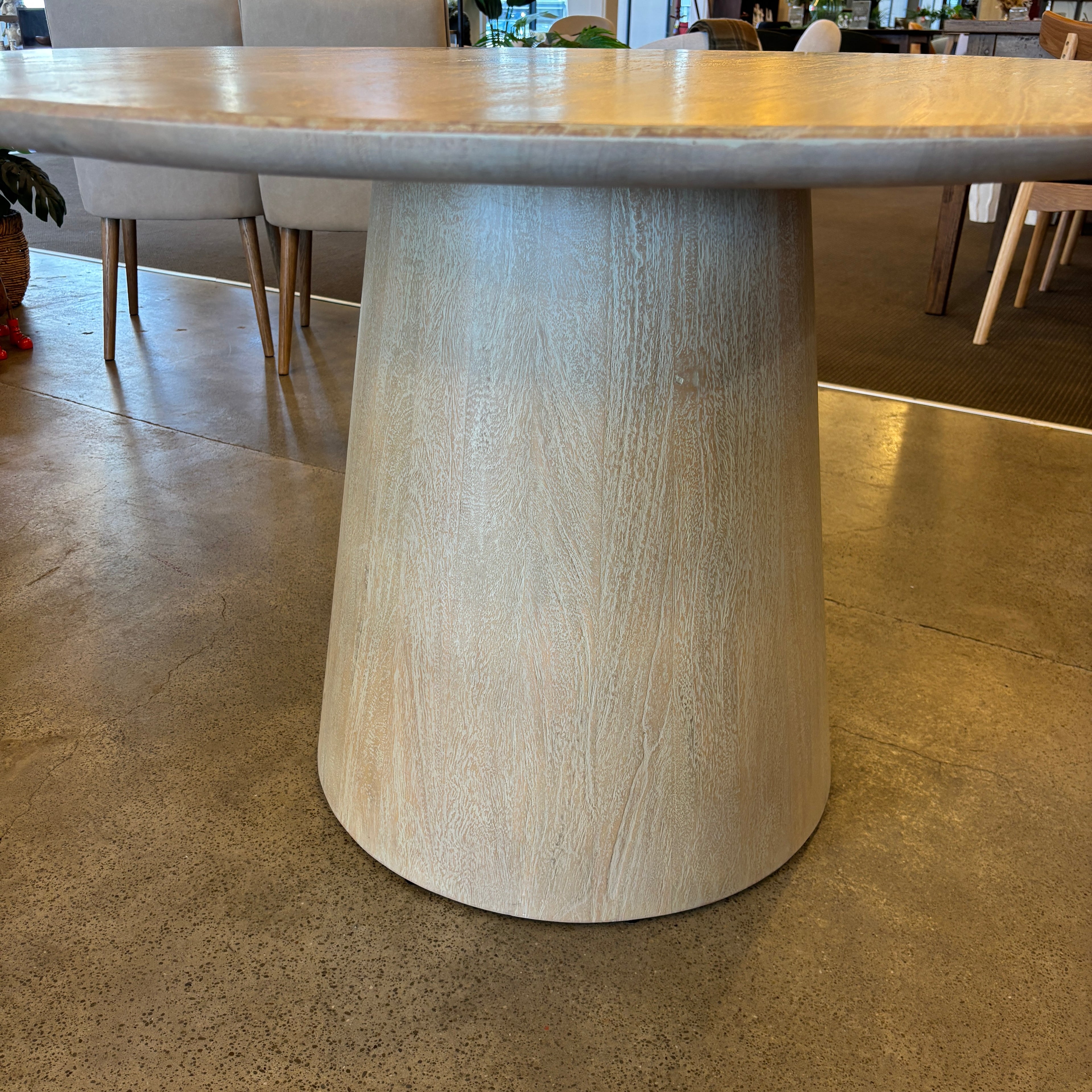 Close-up of the Lando Dining Table's tapered pedestal base, crafted from solid mango wood and finished in a soft Sandblast tone.