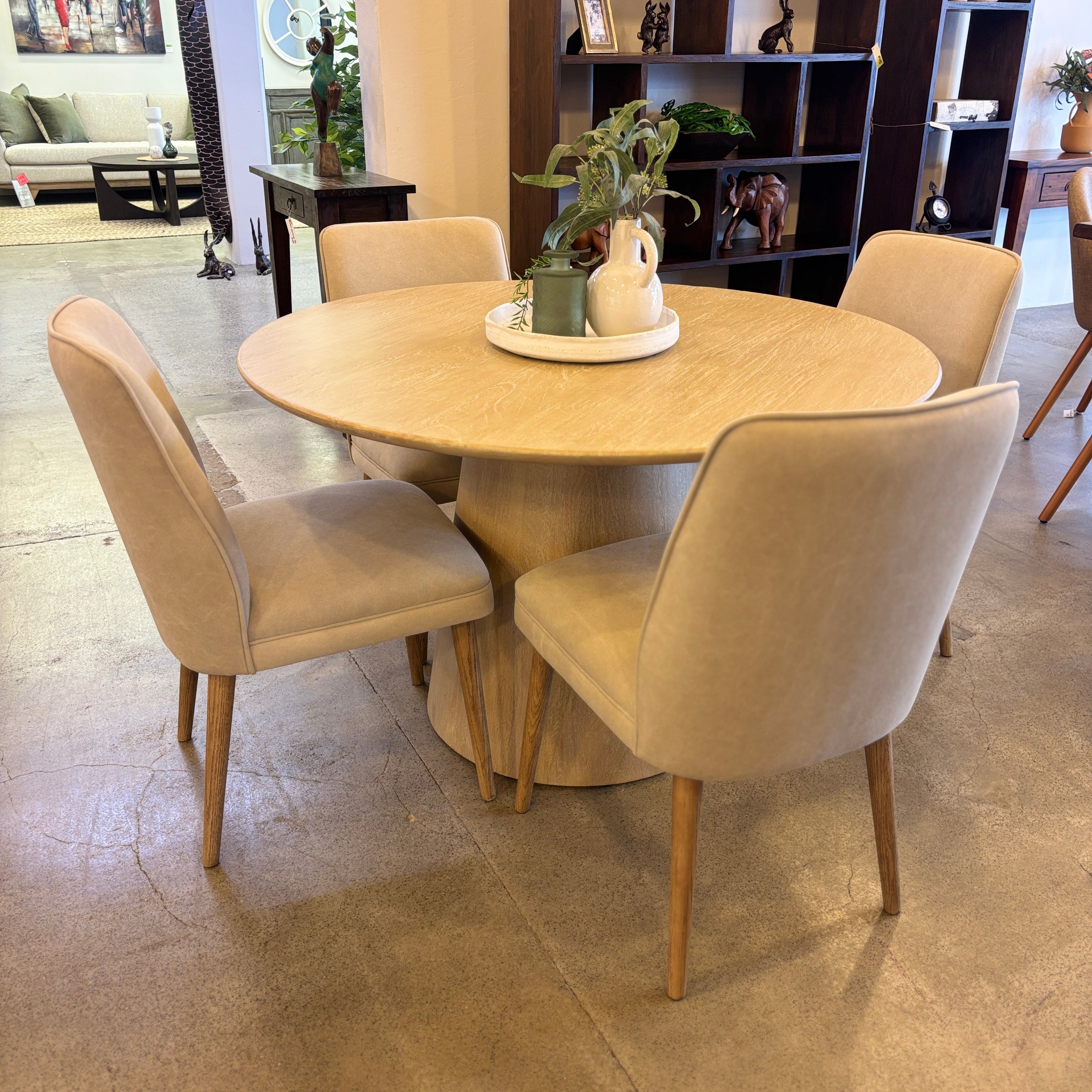 The Lando Dining Table in the Sandblast finish styled with upholstered dining chairs, creating a relaxed and contemporary dining setting.
