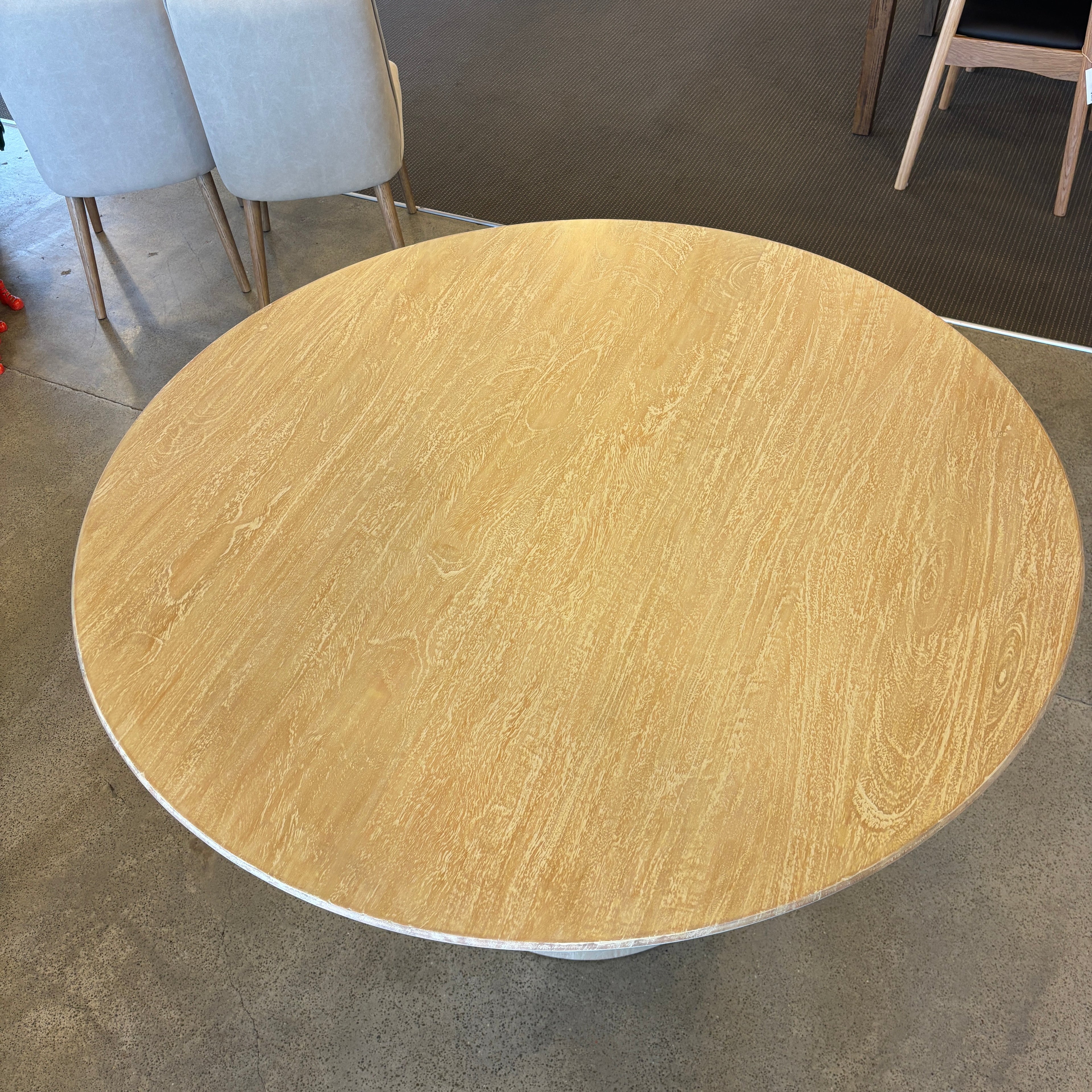 Close-up of the Lando Dining Table's solid mango wood tabletop, highlighting the natural timber grain and textured Sandblast finish.