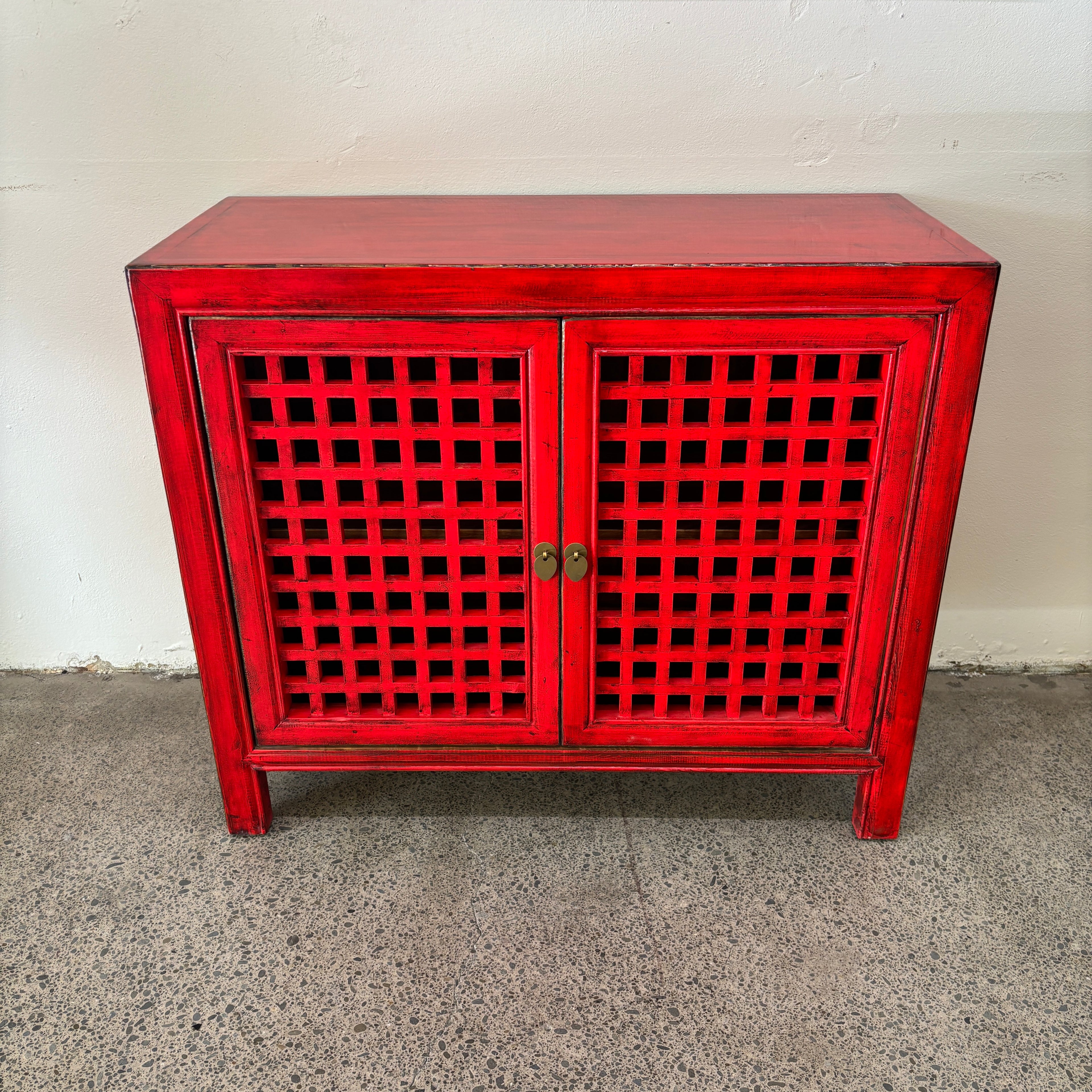 Angled front view of the red Lattice 2 Door Cupboard with two lattice panel doors
