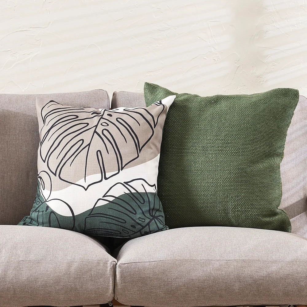 Liana Cushion in olive featuring a green and neutral monstera leaf design