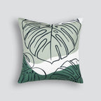 Liana Cushion in olive with monstera leaf design styled on a neutral sofa
