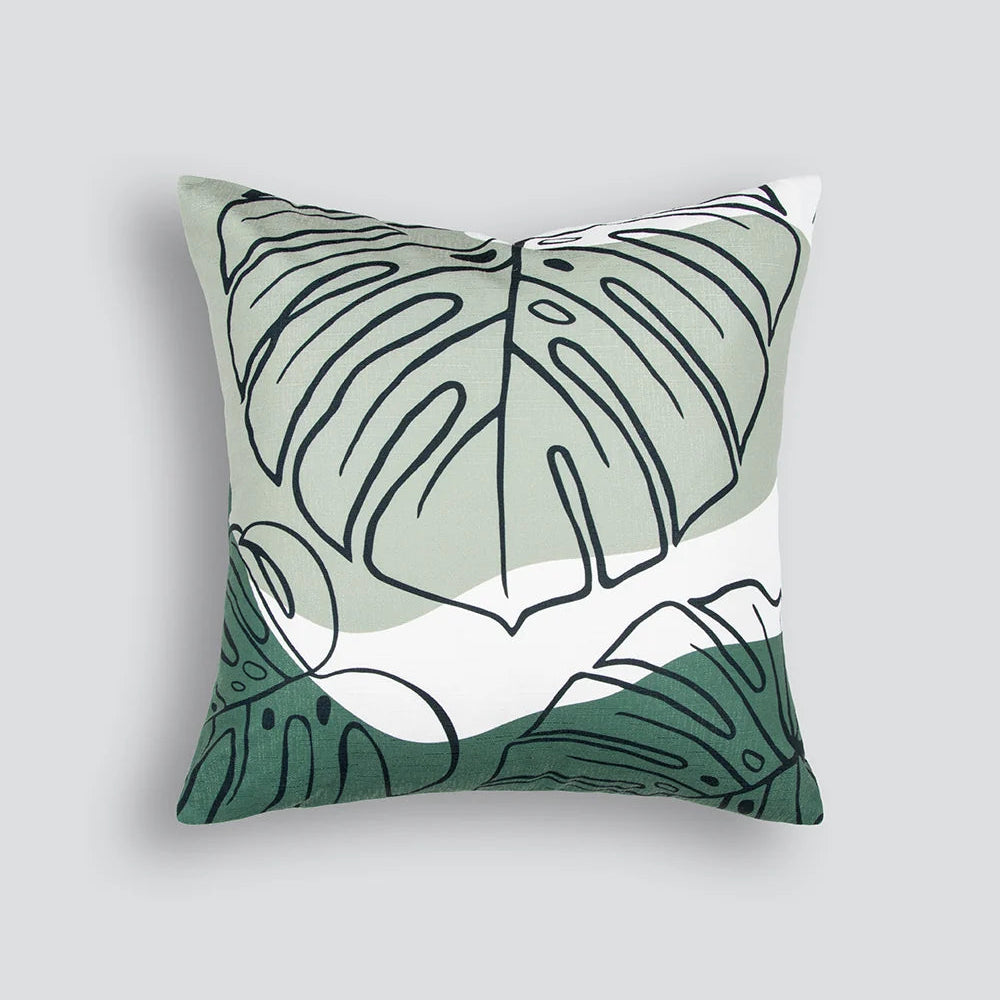 Liana Cushion in olive with monstera leaf design styled on a neutral sofa