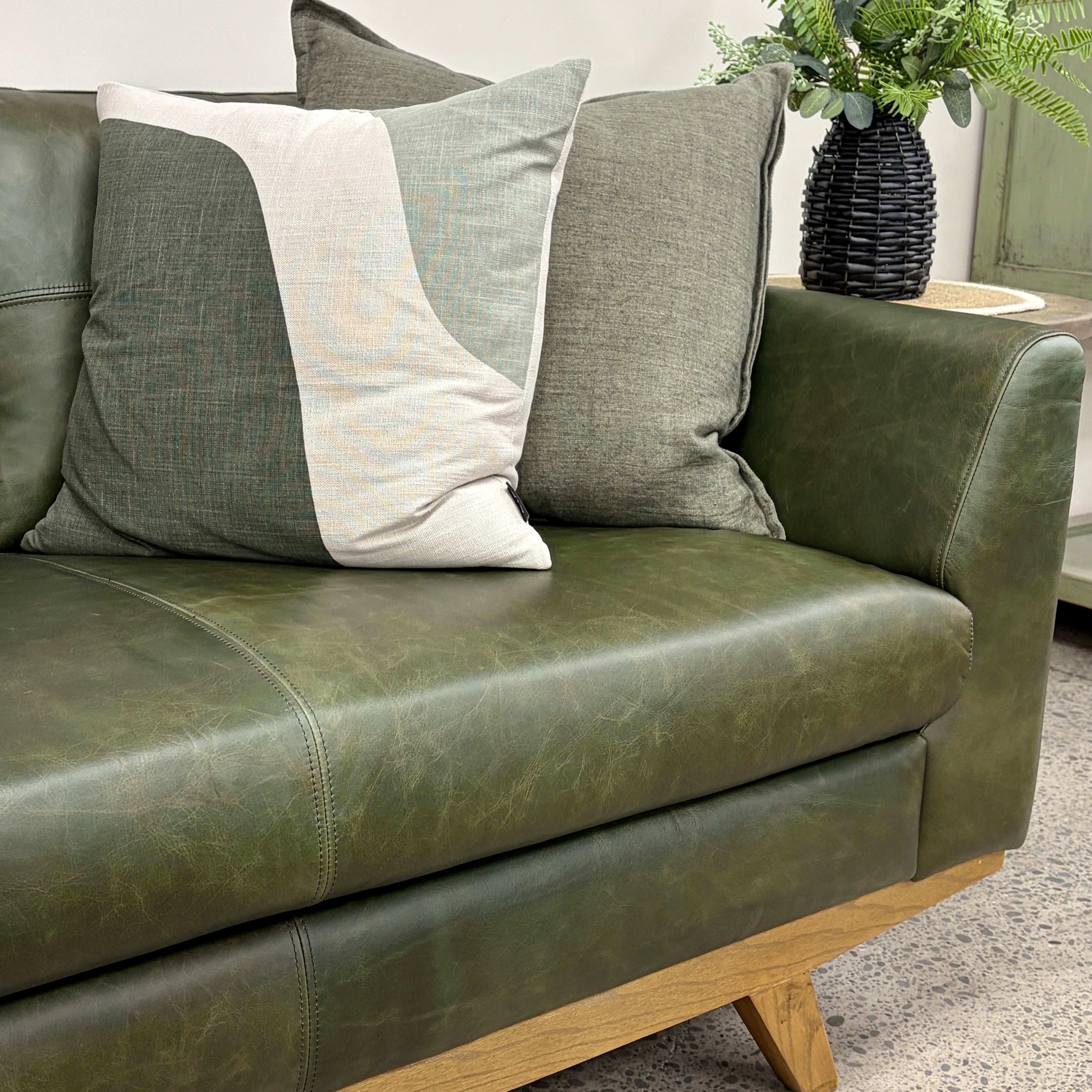 Close-up of the Lucca Sofa's Moss Green leather upholstery, showcasing the natural leather grain, stitched detailing and quality finish.