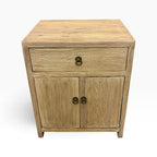 Angled front view of the Lydia Elm Bedside showing the timber top, drawer and double-door cupboard