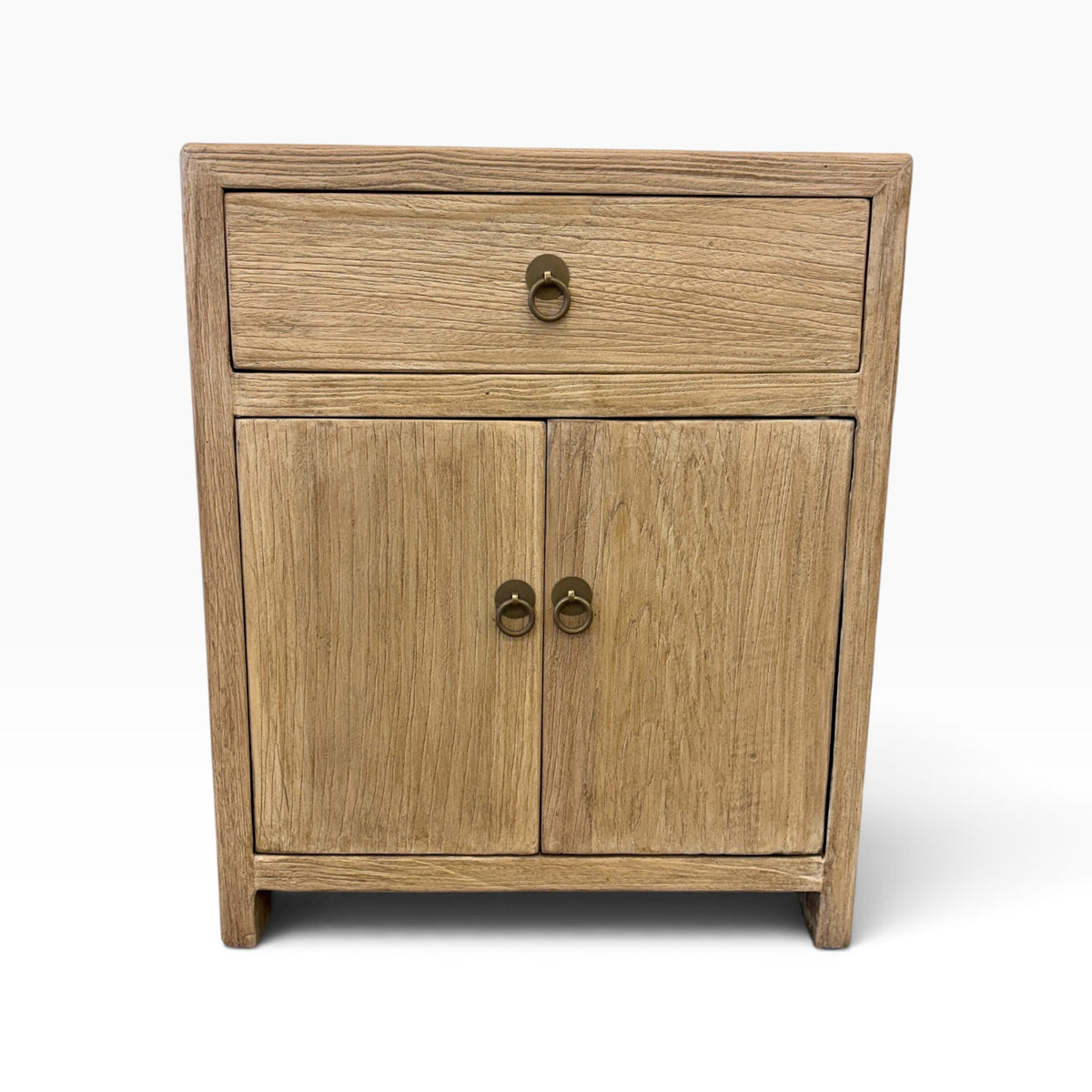 Front view of the Lydia Bedside in natural elm with one drawer, two doors and brass-style ring handles