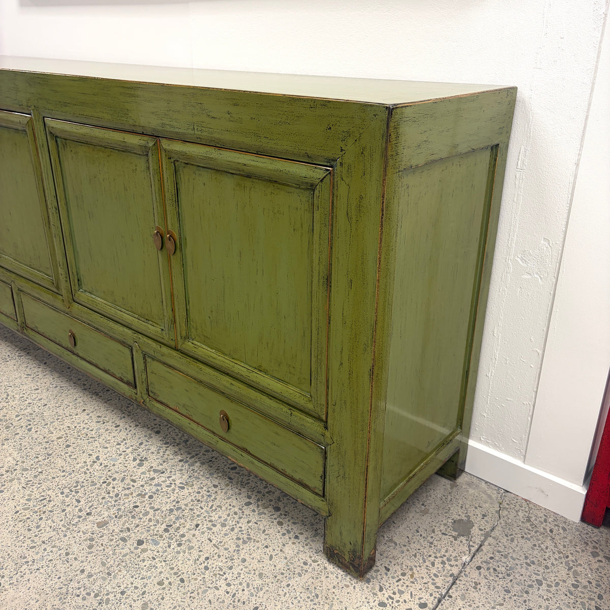 Angled view of Margot Sideboard in Olive showing distressed finish and panelled doors