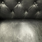 Close-up of the Maxwell Chesterfield sofa's black leather seat and back cushions, highlighting the premium leather and quality craftsmanship.
