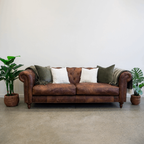 Maxwell Chesterfield sofa in brown leather styled in a contemporary living room.