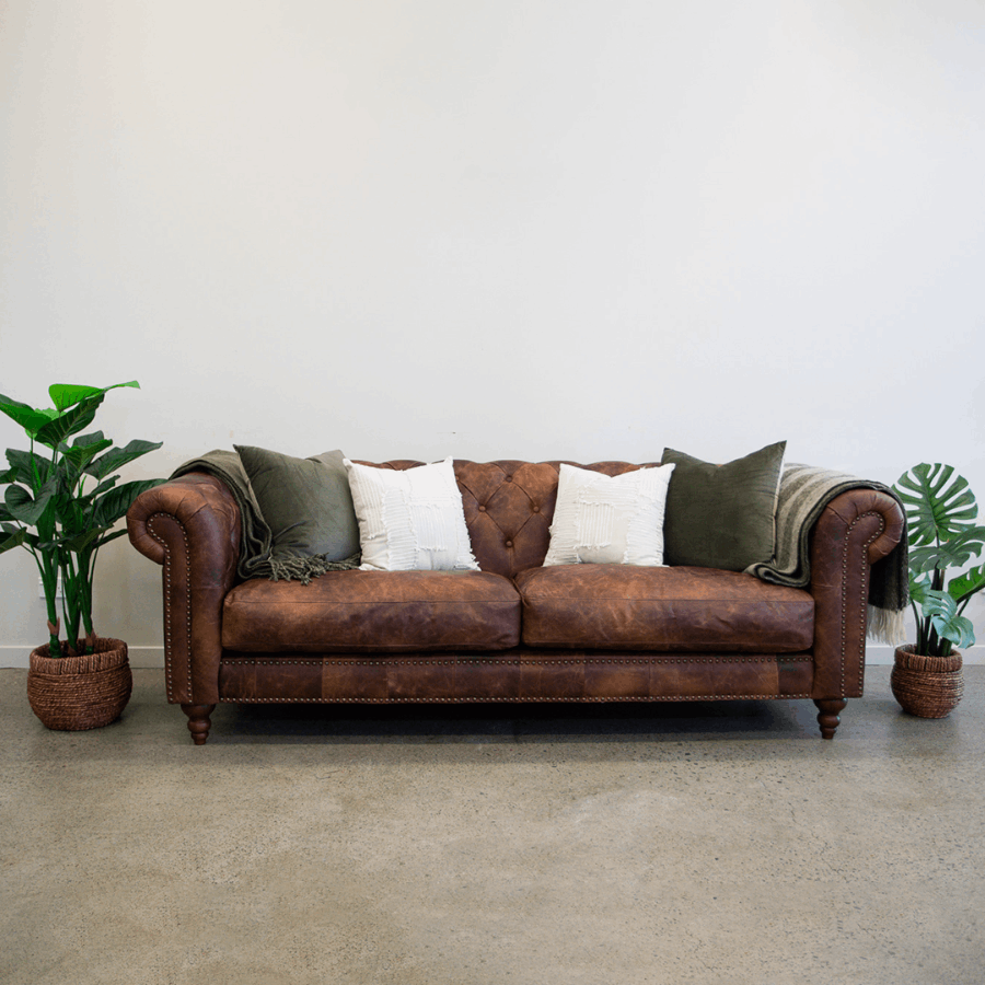 Maxwell Chesterfield sofa in brown leather styled in a contemporary living room.