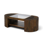 Angled view of the Metz coffee table in cognac mango wood, featuring sculptural curved ends, tempered glass top and lower shelf.