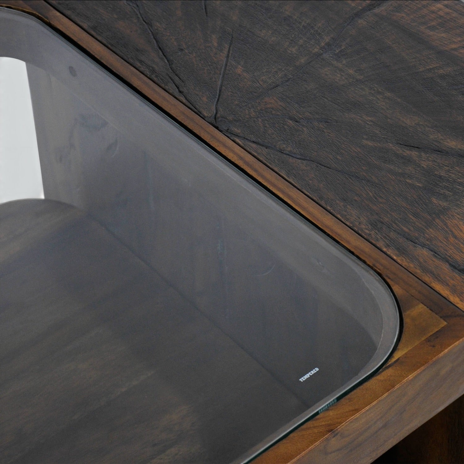 Close-up of the Metz coffee table showing the tempered glass centre and natural grain detailing of the cognac mango wood.