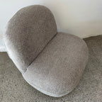 Angled view of the Milo Swivel Chair in Latte with a contemporary curved design and textured fabric upholstery.