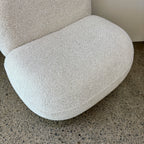 Angled view of the Milo Swivel Chair in Salt with a curved contemporary design and textured fabric upholstery.