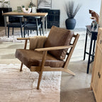 Nero armchair styled in a contemporary showroom with complementary furniture and décor.
