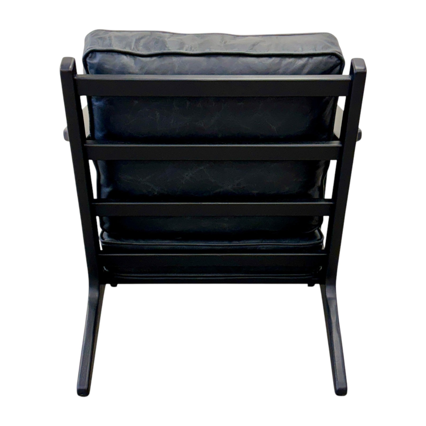 Rear view of the Nero armchair in black leather, highlighting the upholstered finish and black frame.