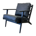 Side profile of the Nero armchair in black leather, showcasing its black frame and contemporary silhouette.