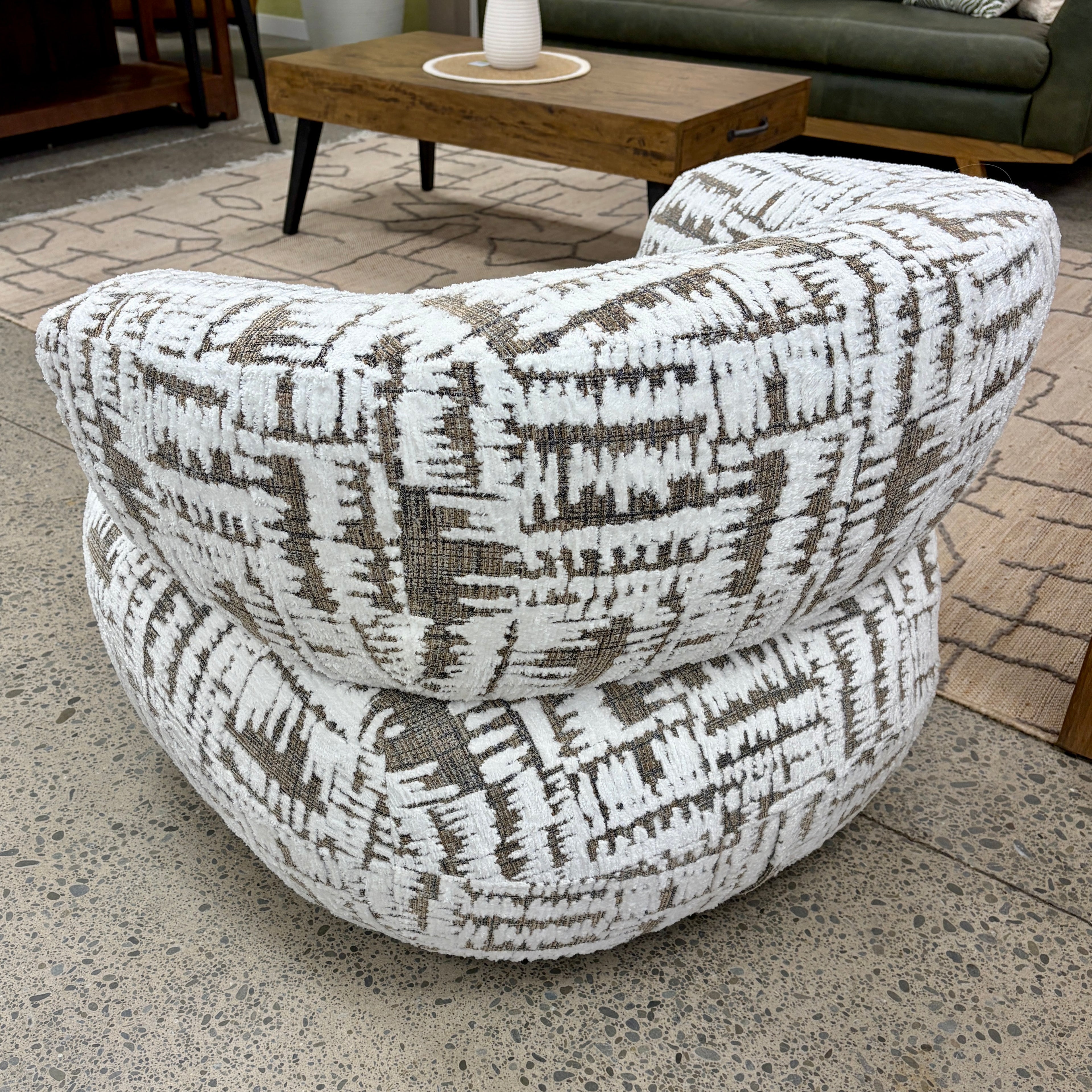 Rear view of the Patsy armchair, highlighting its curved shape and upholstered finish.