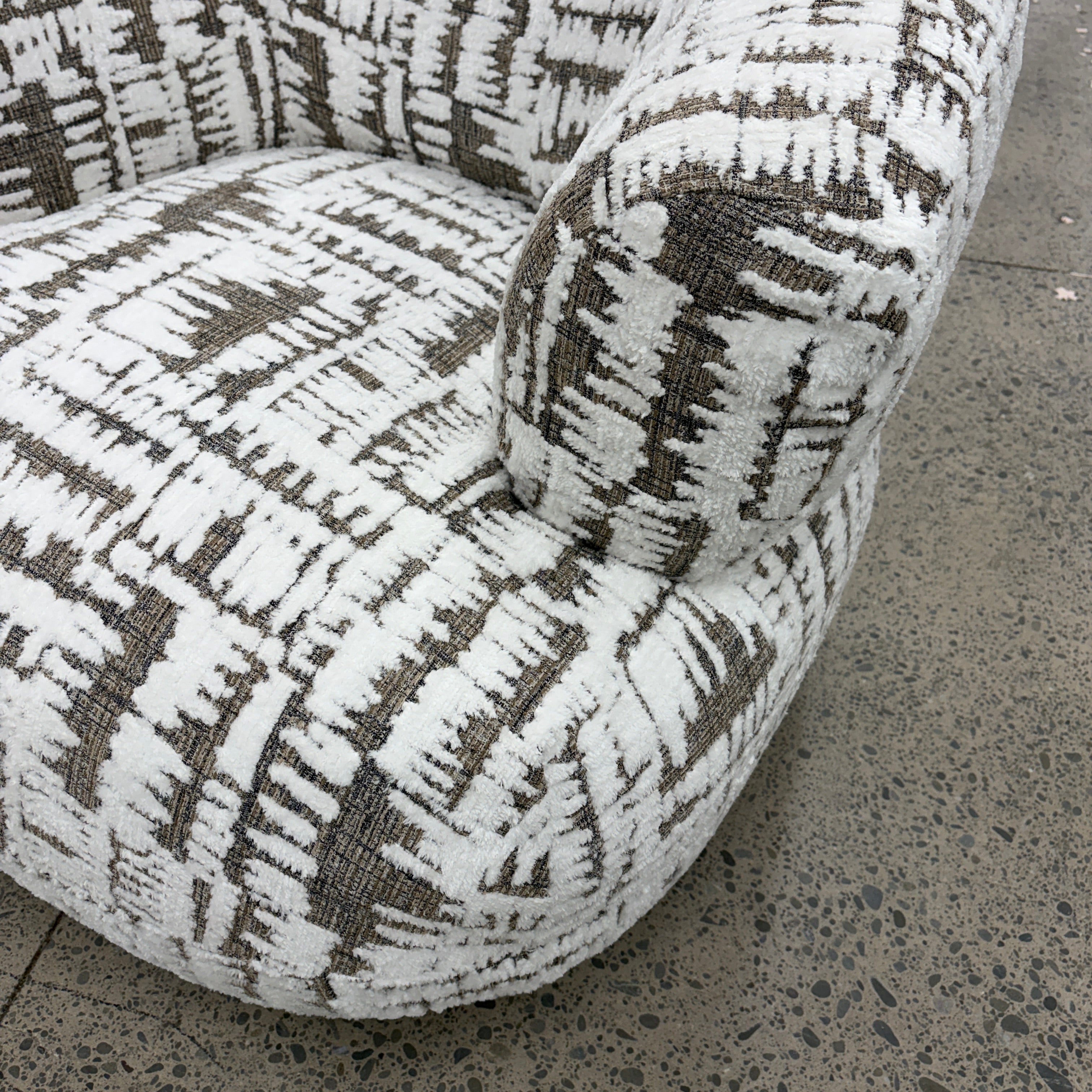Side profile of the Patsy armchair with supportive cushioning and quality fabric upholstery.
