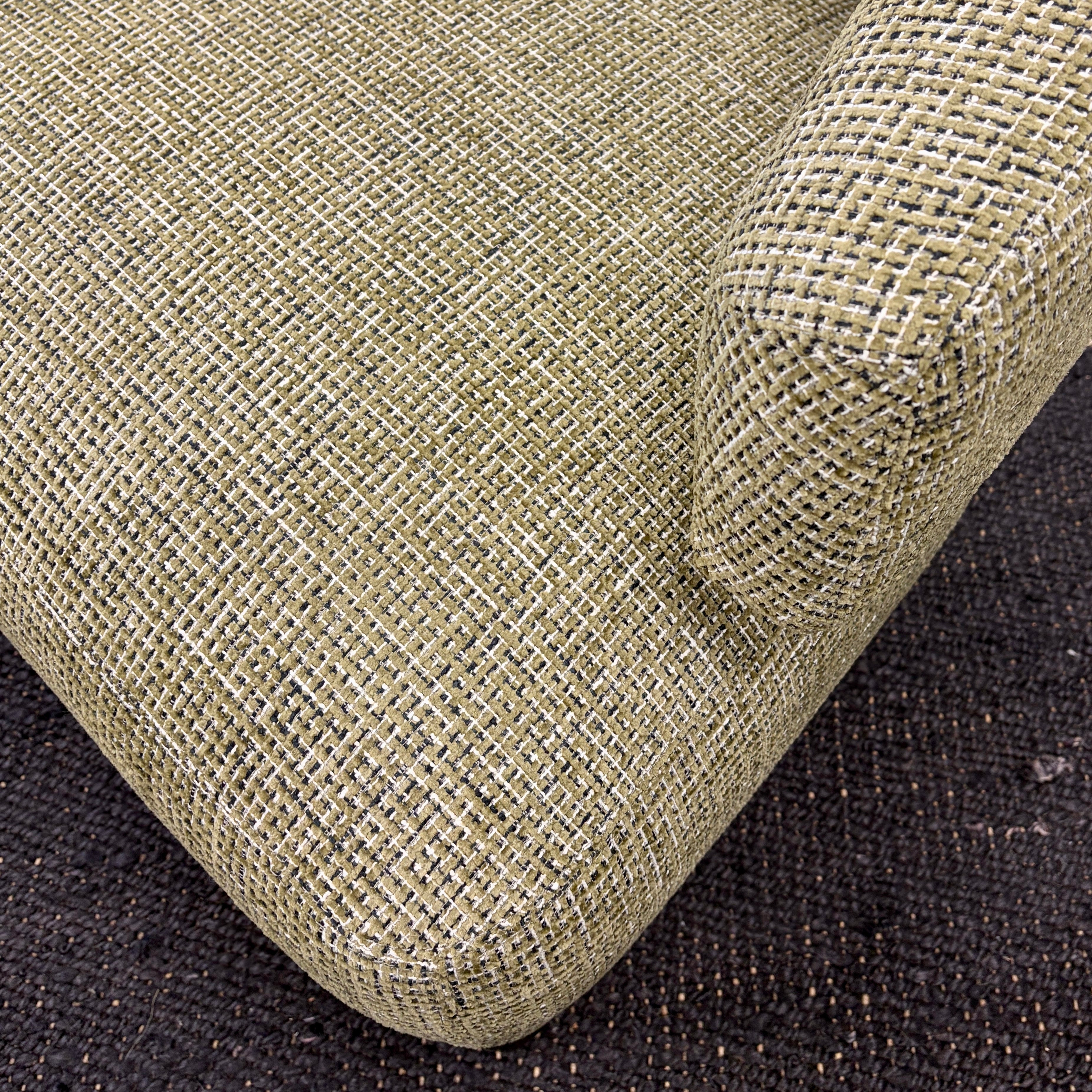 Close-up of the Pepper armchair's textured woven fabric upholstery.