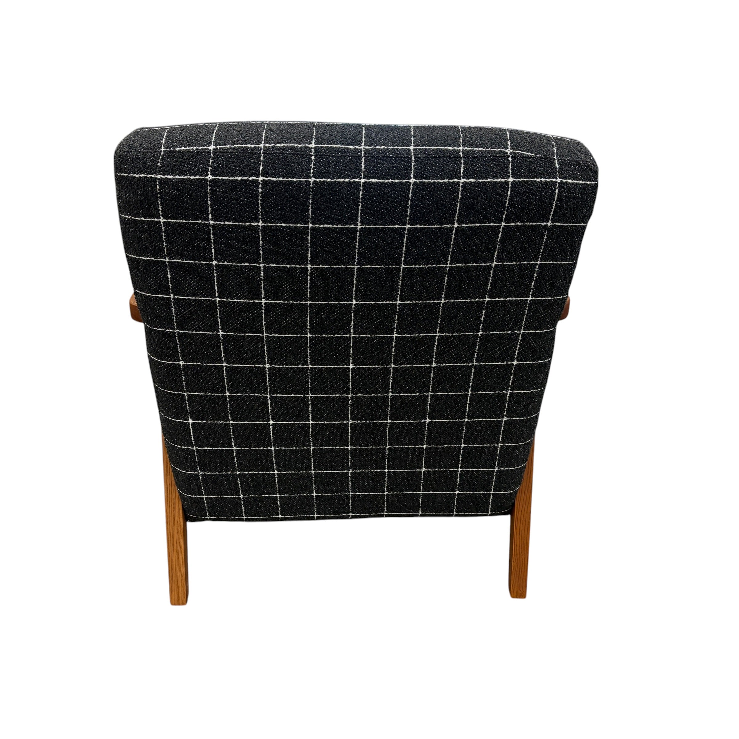 Rear view of the Pia Armchair highlighting its fully upholstered curved back and clean contemporary silhouette.