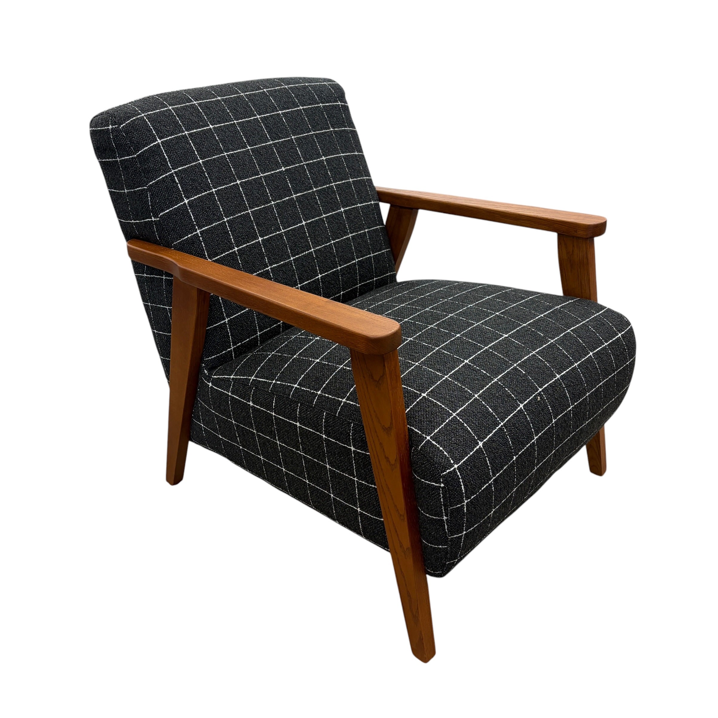 Side profile of the Pia Armchair highlighting its deep seat, curved backrest and contemporary design.