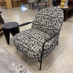 Angled view of the Portia armchair, showcasing its sculptural silhouette and soft upholstery.