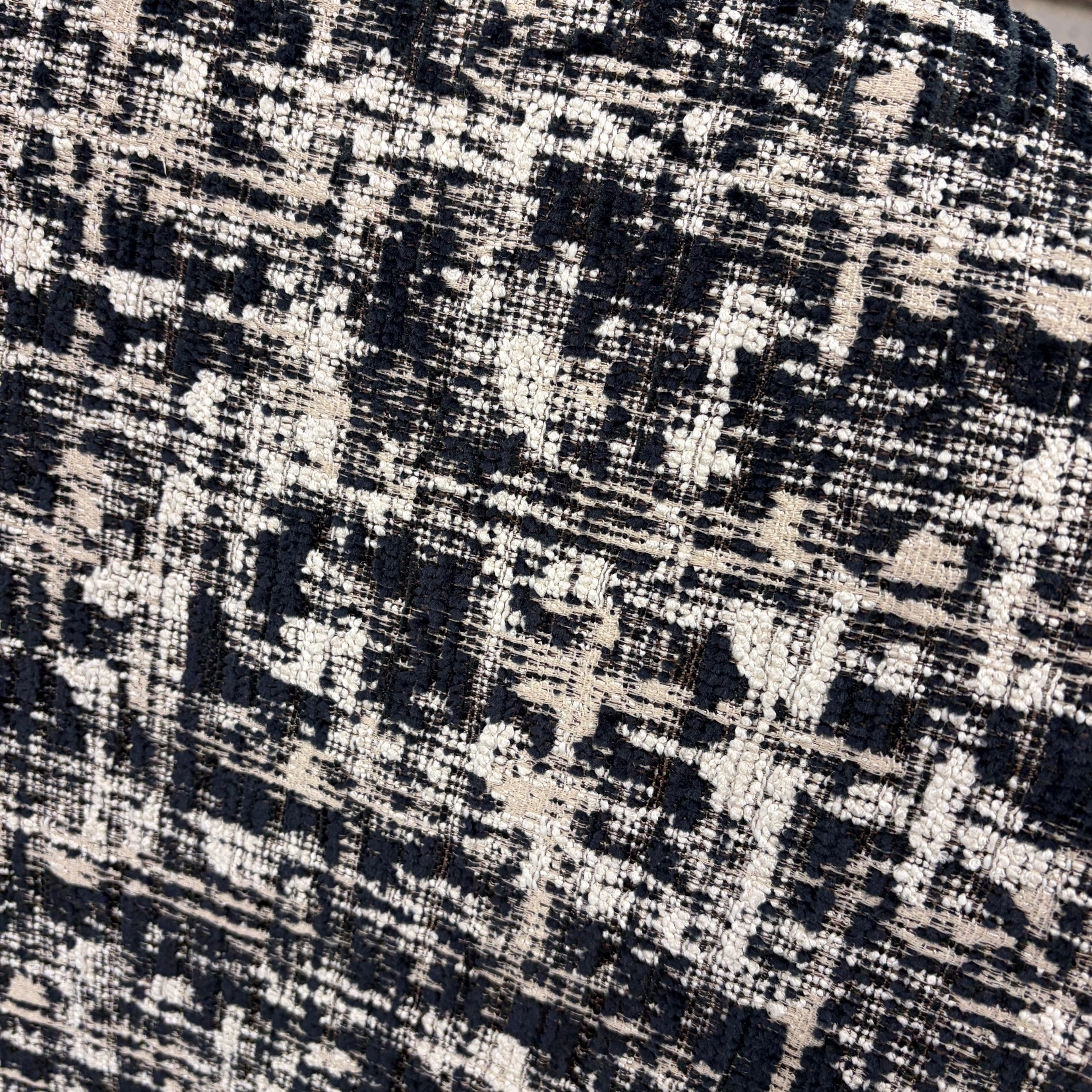 Detail of the Portia armchair's premium black and white woven fabric.