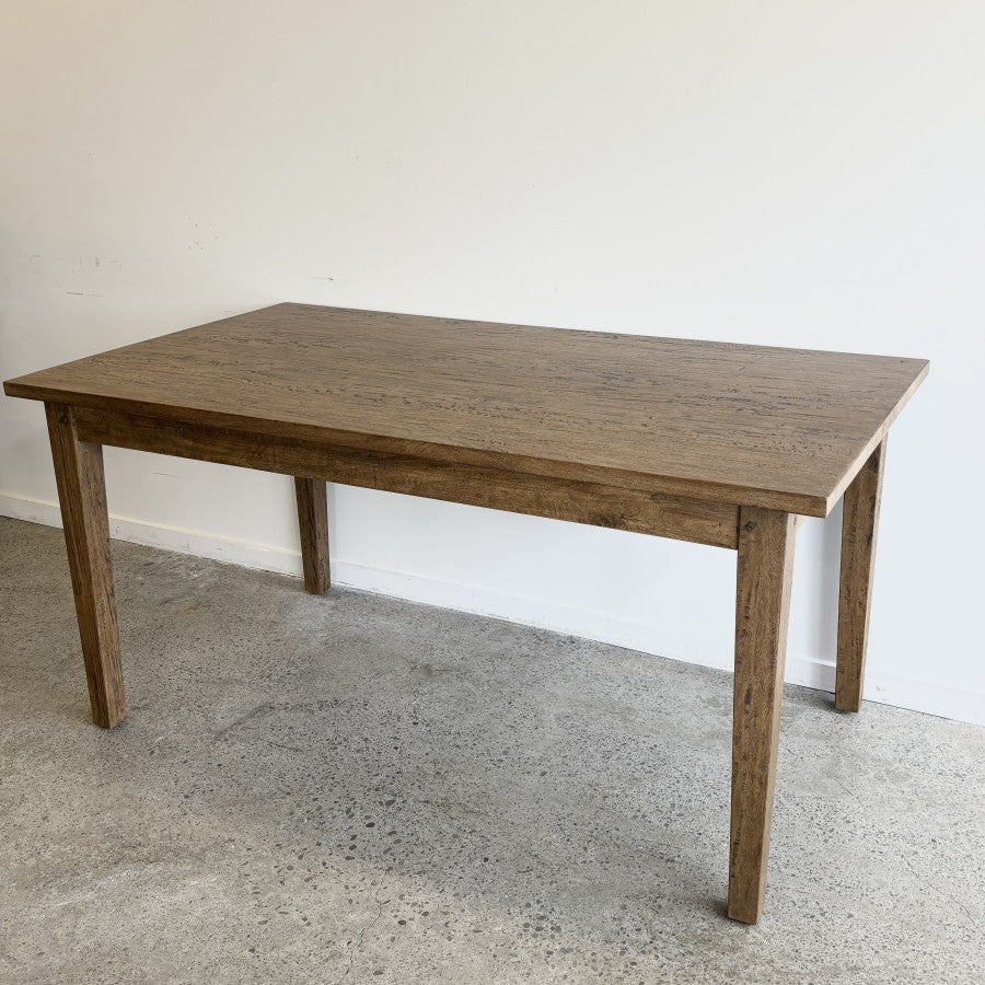 Angled view of the Sienna Dining Table showing its solid mango wood construction and Smokehouse finish.
