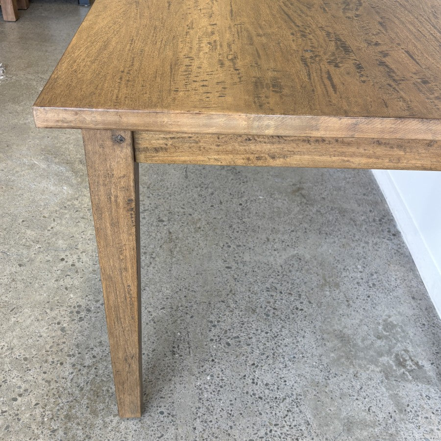 Close-up of the Sienna Dining Table leg showing the solid mango wood construction and Smokehouse finish.