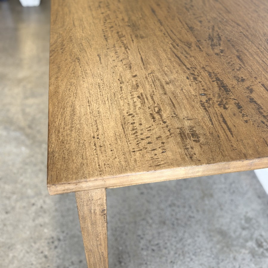 Close-up of the Sienna Dining Table top highlighting the natural grain of the solid mango wood.