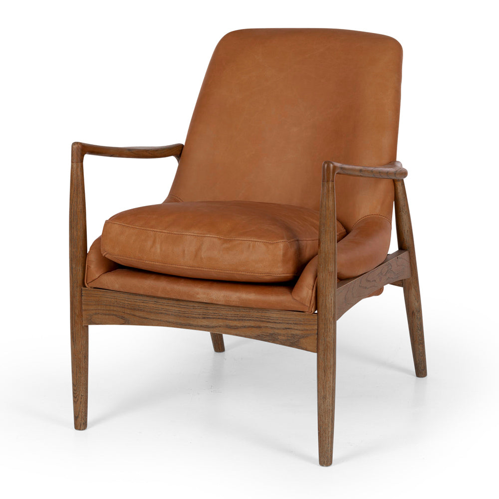 Angled view of the Steiner Occasional Chair in Cognac, showcasing its sculptural oak frame and premium aniline leather upholstery.