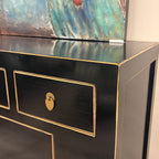 Close-up of Sunny Sideboard Black finish, gold-toned edging and brass drawer handle