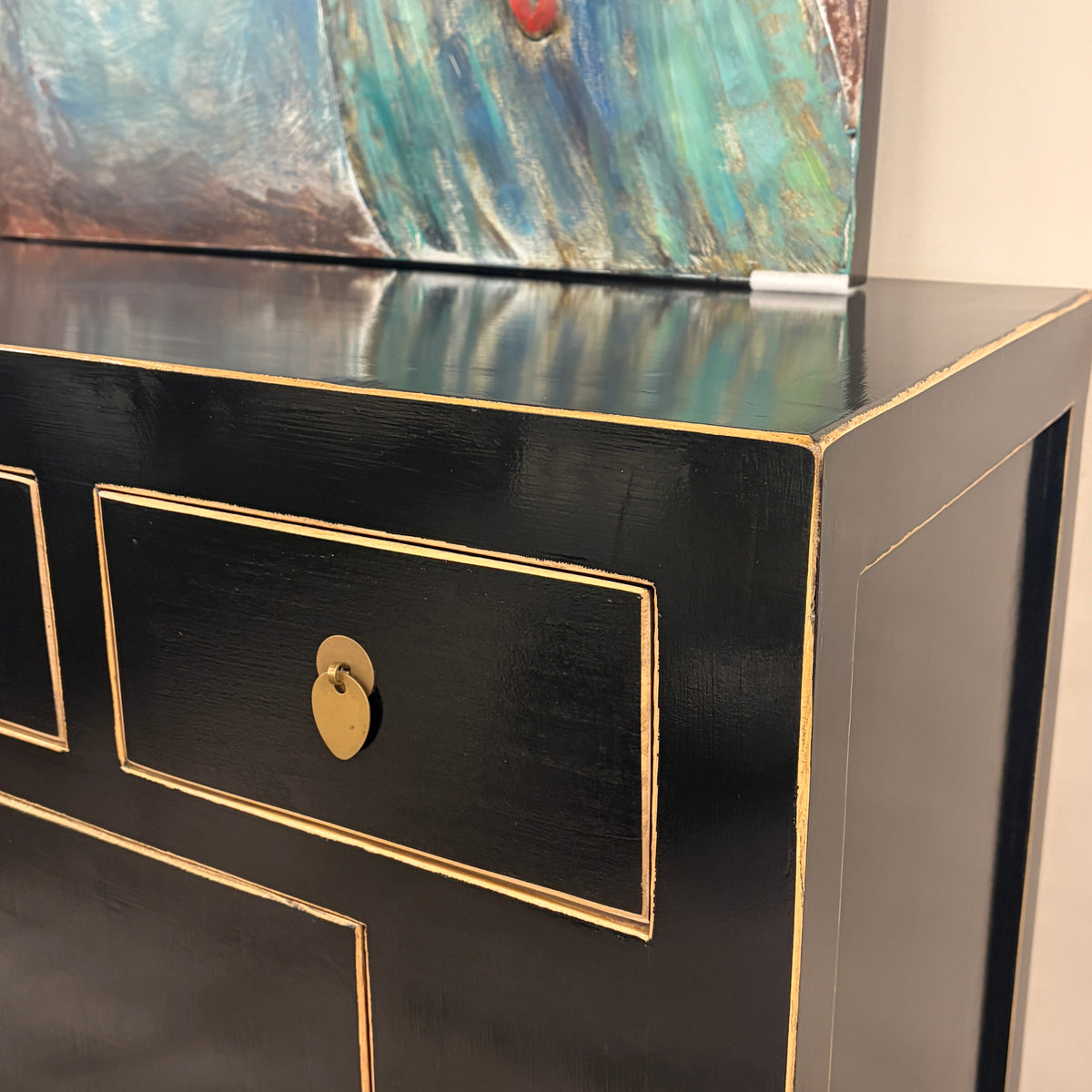 Close-up of Sunny Sideboard Black finish, gold-toned edging and brass drawer handle