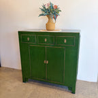 Sunny Sideboard Emerald Green styled with flowers showing rich green finish and compact design
