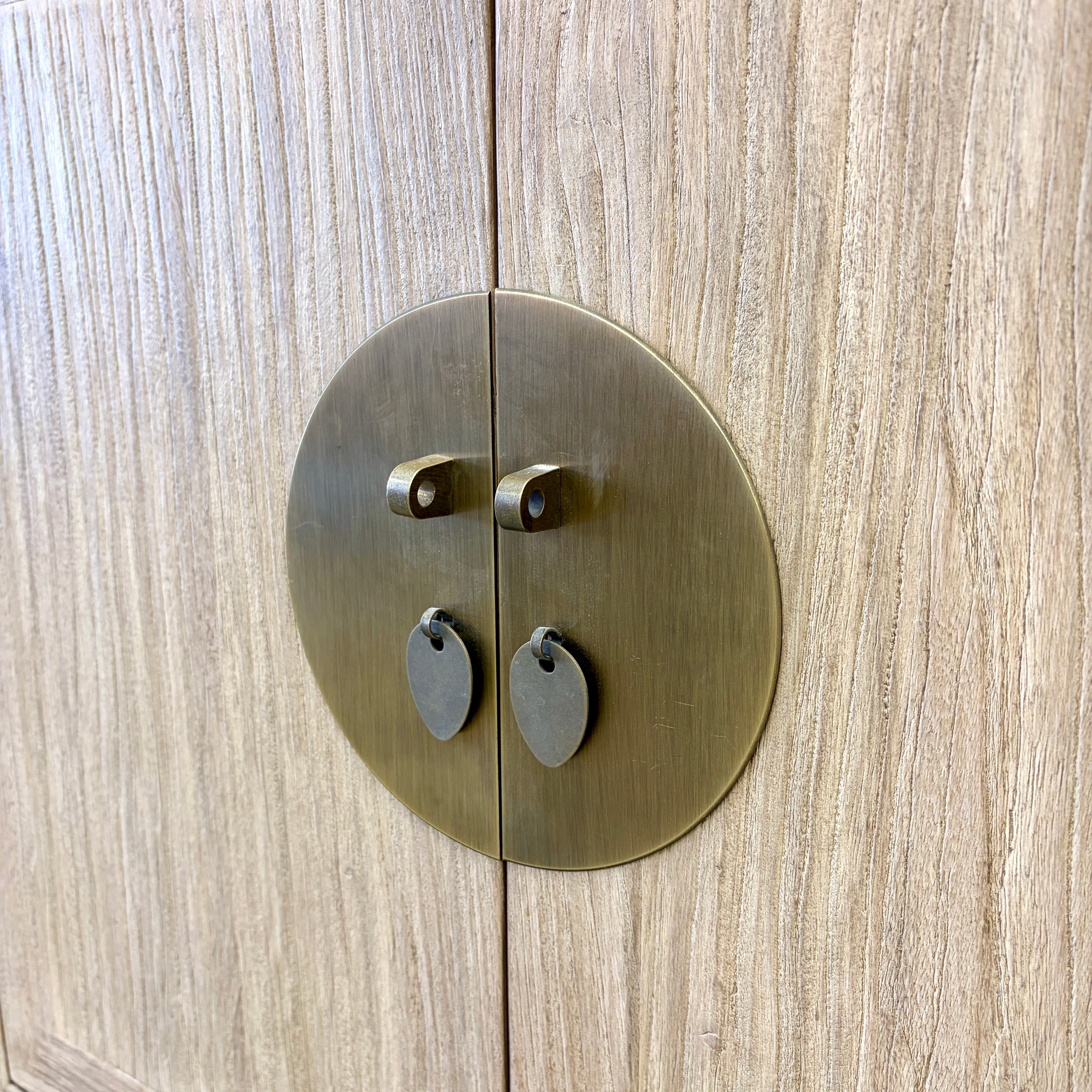 Close-up of the circular antique brass-style door hardware on the Sunny Sideboard in Natural Elm